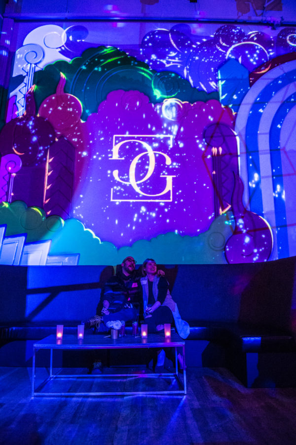 Guests enjoying a VIP booth and the Global Gourmet logo projection mapped among the stars.