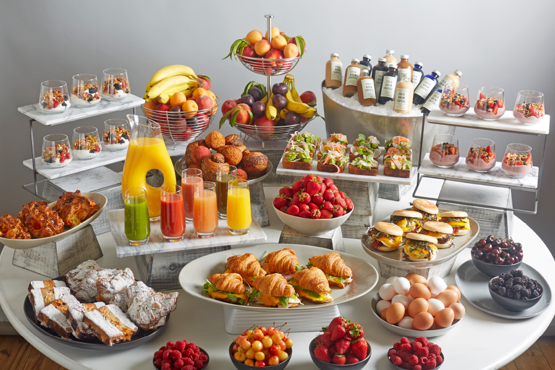 Breakfast Buffet with an assortment of Croissant Sandwiches, Yogurt Parfaits, Pastries, Hot Breakfast Sandwiches, Avocado Toast, Iced Coffees, Fresh Fruit and Juices 